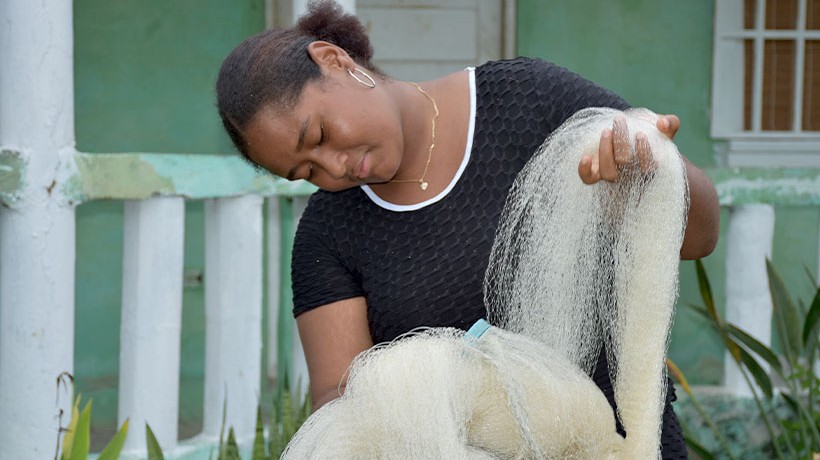 Ashley prepara la red para que su familia pueda salir a pescar. Crédito: ©ACNUDH/Oficina Regional para América Central, Juan Caballero